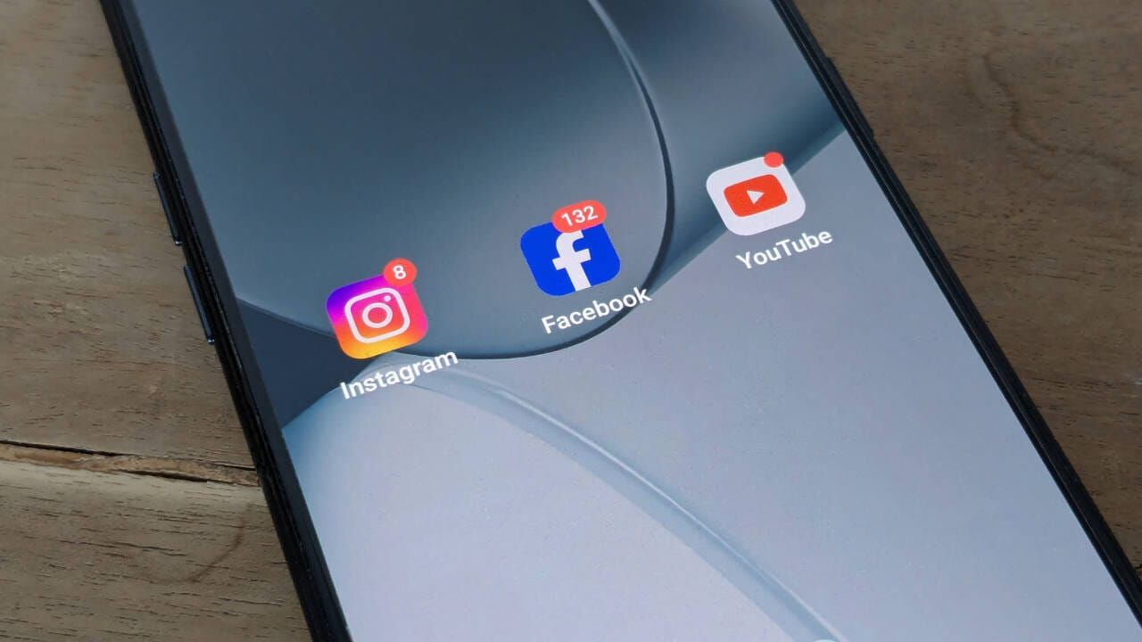 Ein Smartphone-Bildschirm zeigt Instagram, Facebook und YouTube-App-Symbole an.